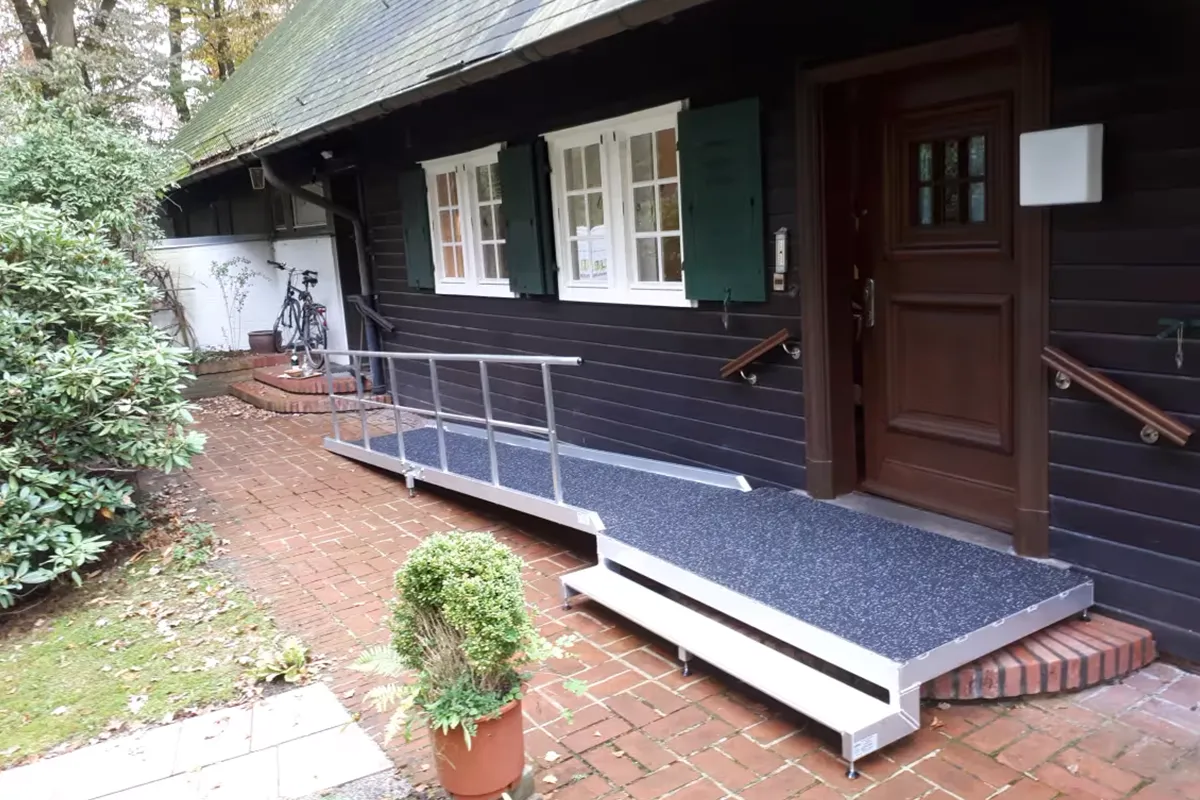Rampe mit Podest im Außenbereich vor einem Haus seitlich verlaufend. Aufbau durch Niedersachsen Lifte.