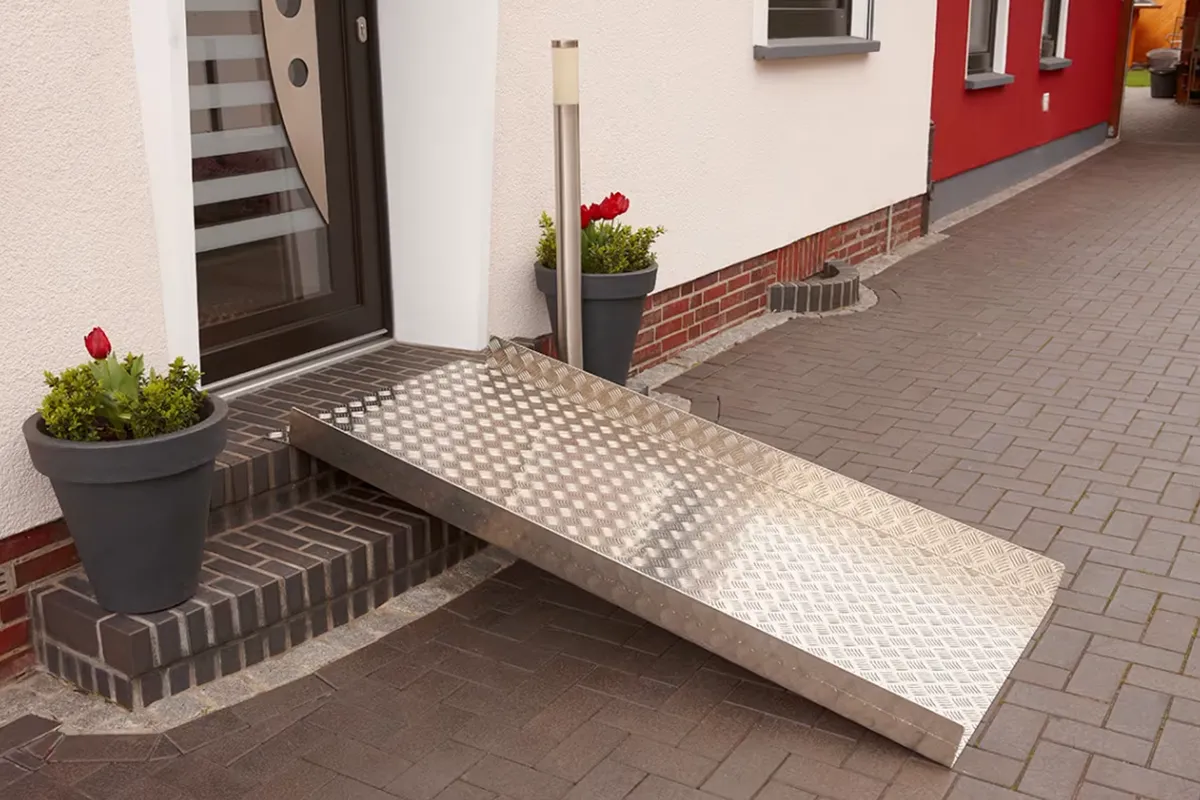 Klapprampe von Niedersachsen Lifte steht Aufgebaut vor einer Haustür um die Stufe davor zu überwinden