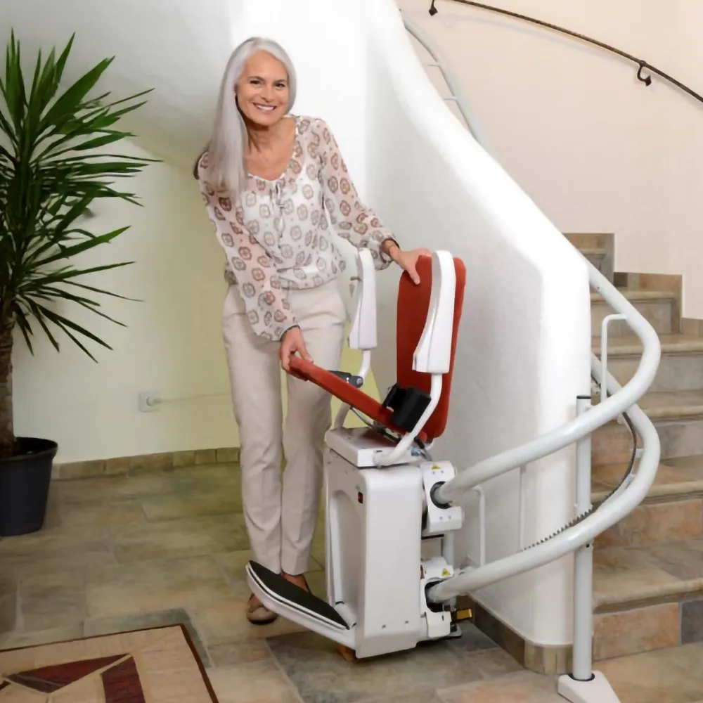 Eine Frau steht an einem Treppenlift und klappte den Sitz hoch. Niedersachsen Lifte bietet Treppenlifte in vielen Variationen und Designmöglichkeiten